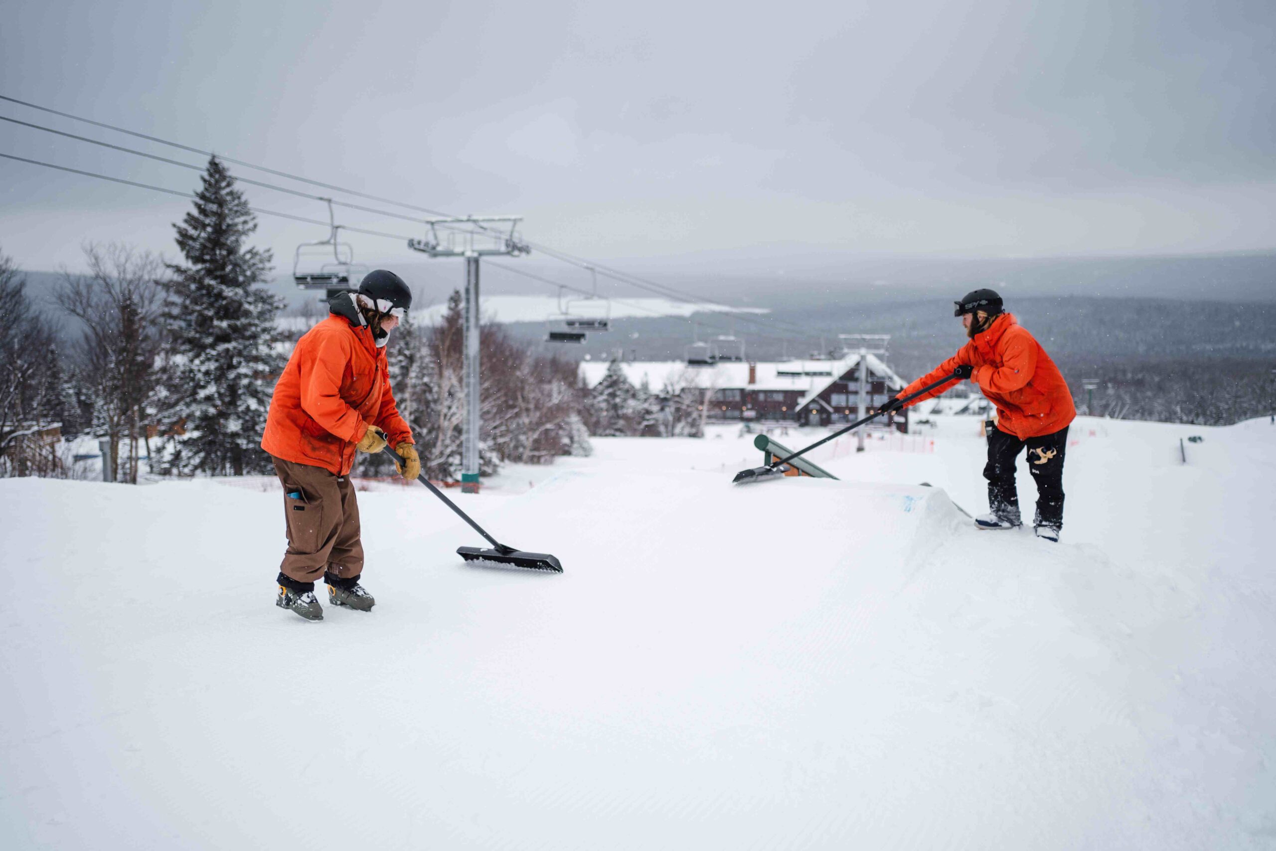 Two terrain park attendants rake for opening